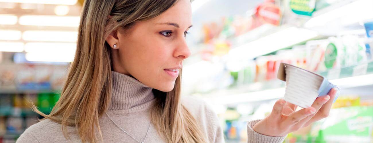 woman inspecting nutrition facts of yogurt