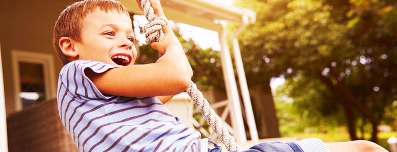 kid happy swinging on a tire