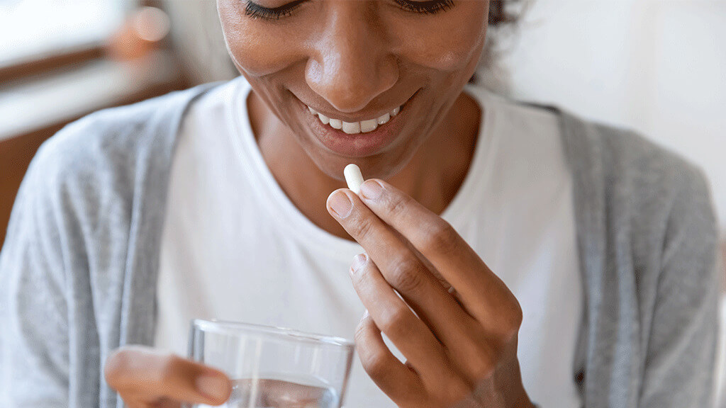 woman taking pill capsule