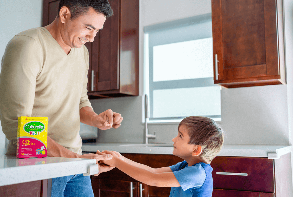 father serving son Culturelle Kid's probiotic chewables in the kitchen